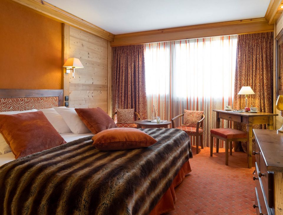 grand lit double et espace détente avec des sièges-hotel luxe courchevel